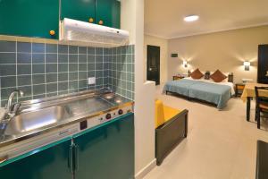 - une cuisine avec évier et un lit dans une chambre dans l'établissement Maria Beach Hotel, à Kíssamos