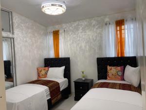2 camas en un dormitorio con cortinas naranjas en 7DR Apt in Prime Location Near Monumental Area, en Santiago de los Caballeros