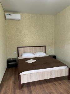 a bedroom with a bed and a air conditioner at Guest House u Feliksa in Tsandrypsh