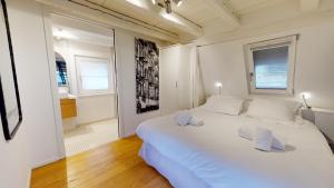 - une chambre blanche avec un grand lit blanc et des oreillers blancs dans l'établissement Le Lohkäs - LOFT Triplex Ultra Design Petite France, à Strasbourg