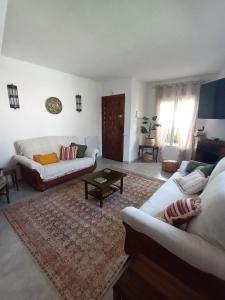 a living room with two couches and a rug at NUEVA NERJA Pueblo Andaluz Casa Grafton in Nerja