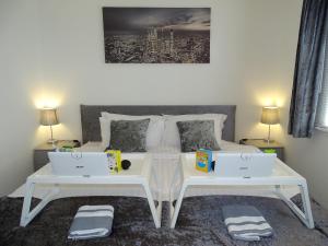a bedroom with two white tables and two laptops at Stony Apartment House in Doncaster