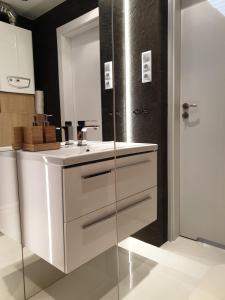 y baño con lavabo blanco y espejo. en Apartament pod Jaworzyną, en Krynica-Zdrój