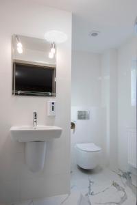 a white bathroom with a sink and a toilet at Western Hills in Gdańsk