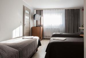a hotel room with two beds and a television at Western Hills in Gdańsk