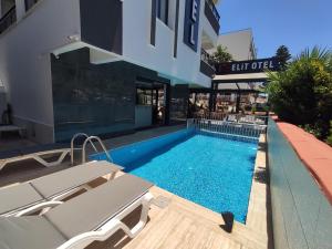 a swimming pool in front of a building at Didim Elit Otel in Didim