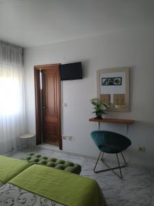 a bedroom with a green bed and a chair at Pension Fercomar in Sanxenxo
