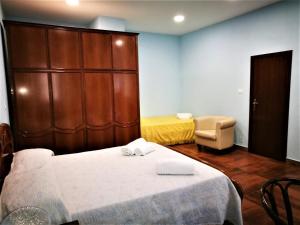 a room with a bed and a chair and a cabinet at CASA VACANZE, in centro città in Caltanissetta