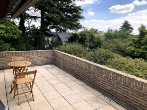 a patio with a table and chairs and a brick wall at La Clé de la Forêt in Tervuren