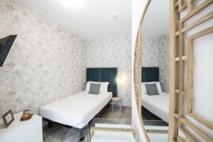 two beds in a room with a mirror at Hotel Brennero in Verona
