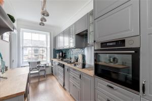 a kitchen with stainless steel appliances and a wooden floor at Glamorous flat near City Centre in Edinburgh