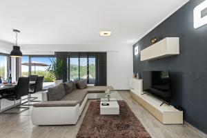 een woonkamer met een bank en een tv bij Villa Leandra in Novigrad Istria