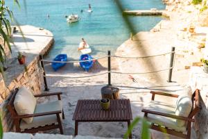 a view of a beach with chairs and a table at Orsula's Beach House in Vela Luka