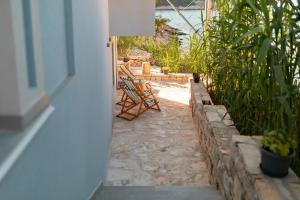 eine Terrasse mit 2 Stühlen und einem Tisch in einem Haus in der Unterkunft Orsula's Beach House in Vela Luka