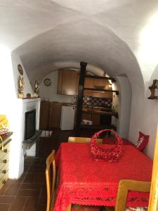 uma cozinha com uma mesa com uma toalha de mesa vermelha em La Casa della Volpe em Collimento