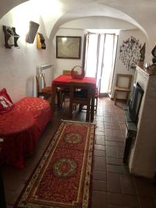 uma sala de estar com uma mesa e um tapete vermelho em La Casa della Volpe em Collimento