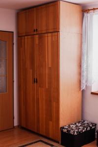 un gran armario de madera en una habitación con reposapiés en Gazdova chalupa, en Vavrišovo