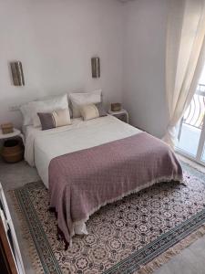 een slaapkamer met een groot bed en een raam bij NUEVA NERJA Pueblo Andaluz Casa Grafton in Nerja