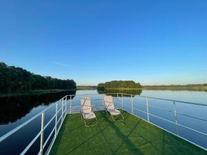 two chairs sitting on the deck of a boat at AQUA Bērzgale in Bērzgale