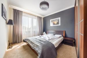 a bedroom with a bed and a large window at Apartamenty Sun & Snow Sadyba Orłowska in Gdynia