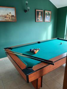 einen Snookertisch in einem Zimmer mit Gemälden an der Wand in der Unterkunft Twoja Przystań Rodzinna in Jastrzębia Góra