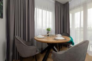 a dining room with a wooden table and chairs at Baltic Apartment Marynarska by Noclegi Renters in Sarbinowo