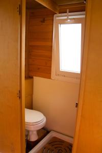 Un pequeño baño con inodoro y ventana. en House boat V al Poetto 2 pax piu' 1, en Poetto 11 fotos más