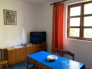 a dining room with a blue table and a television at Monterama Apartments in Sutomore
