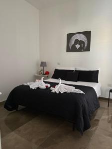 ein Schlafzimmer mit einem großen Bett mit Kleidung darauf in der Unterkunft Le Mirage Residence in Castellammare di Stabia