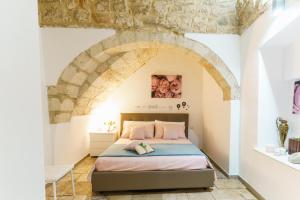 a bedroom with a bed in a room with a stone wall at Porto di Mare Apartment near the sea in Molfetta