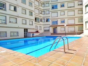 una piscina en un complejo de apartamentos con un edificio en Desconectaengalicia Cesteiros, piscina, 100m Playa Silgar, en Sanxenxo