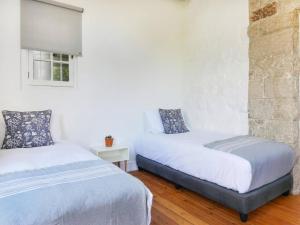a bedroom with two beds and a brick wall at Behr Road Apartment with sea view patio in Cape Town