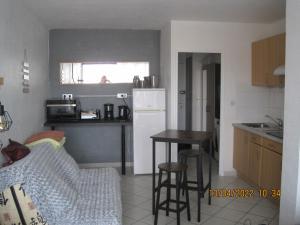 a kitchen with a white refrigerator and a table at naturiste in Cap d'Agde