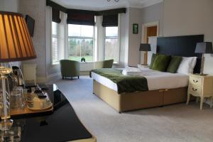 a bedroom with a large bed and a desk with a table sidx sidx at LakeSide House in Keswick