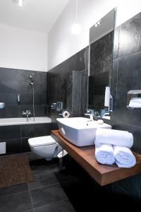 沙莫林的住宿－Arena Hotel Samorin，浴室配有盥洗盆、卫生间和浴缸。