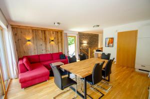 a living room with a red couch and a table at Schmitten Finest Apartments by All in One Apartments in Zell am See