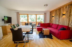 a living room with a red couch and a table at Schmitten Finest Apartments by All in One Apartments in Zell am See
