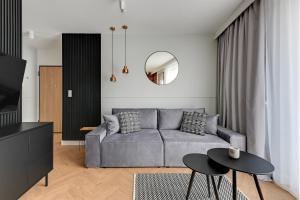 a living room with a gray couch and a table at Aura 40 City Center & Free Parking by Downtown Apartments in Gdańsk