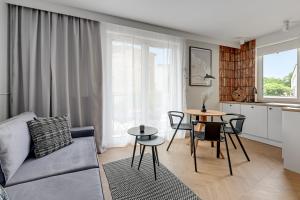 ein Wohnzimmer mit einem Sofa und einem Tisch in der Unterkunft Downtown Apartments City Center Aura 40 Apartments & Parking in Danzig