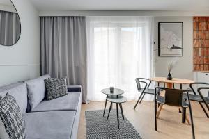 a living room with a couch and a table at Aura 40 City Center & Free Parking by Downtown Apartments in Gdańsk