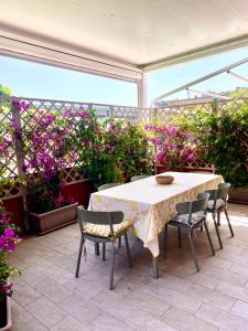 a table and chairs on a patio with flowers at La Casa di Greta in Celle Ligure