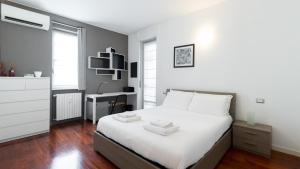 1 dormitorio con cama blanca y escritorio en Italianway - Tagiura 8, en Milán
