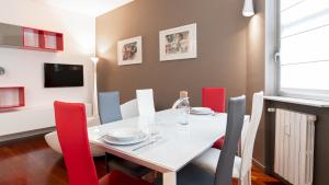 comedor con mesa blanca y sillas rojas en Italianway - Tagiura 8, en Milán