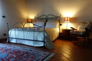 a bedroom with a bed and a chair and a lamp at Monte Bibele in Monterenzio