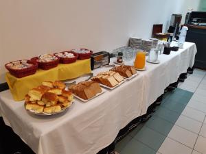 a long table with various types of bread and pastries at Hotel Plaza Roma in Buenos Aires