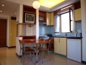 a kitchen with a wooden table and chairs in it at Stefanakis Villas - Car Included in Livadia