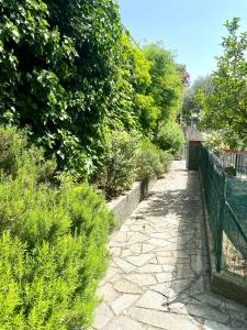 a stone walk way with a fence and bushes at La Casa di Greta in Celle Ligure +10 photos