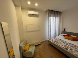 ein kleines Schlafzimmer mit einem Bett und einem Stuhl in der Unterkunft Casa Vacanze Caramagna 2 in Aci Castello