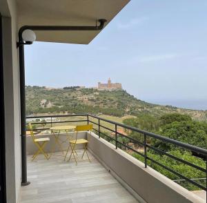 a balcony with a table and a view of the ocean at La Casa del Riccio in Tindari