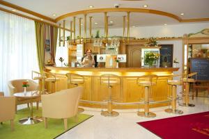 a woman sitting at a bar in a salon at Park Hotel Laim Serviced Apartments in Munich